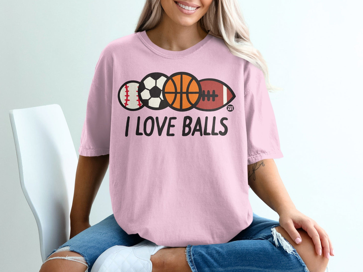 Pink t-shirt with "I LOVE BALLS" text and sports balls graphic.