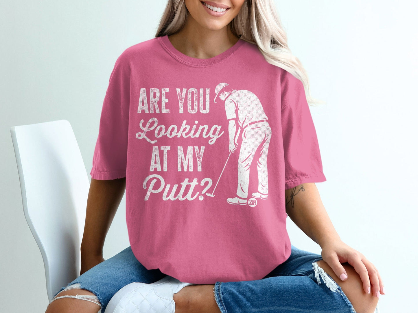 Pink t-shirt with "ARE YOU LOOKING AT MY Putt?" graphic of golfer.
