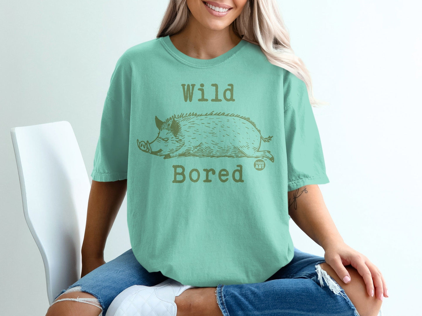 Mint green t-shirt with a sleeping wild boar graphic and "Wild Bored" text.