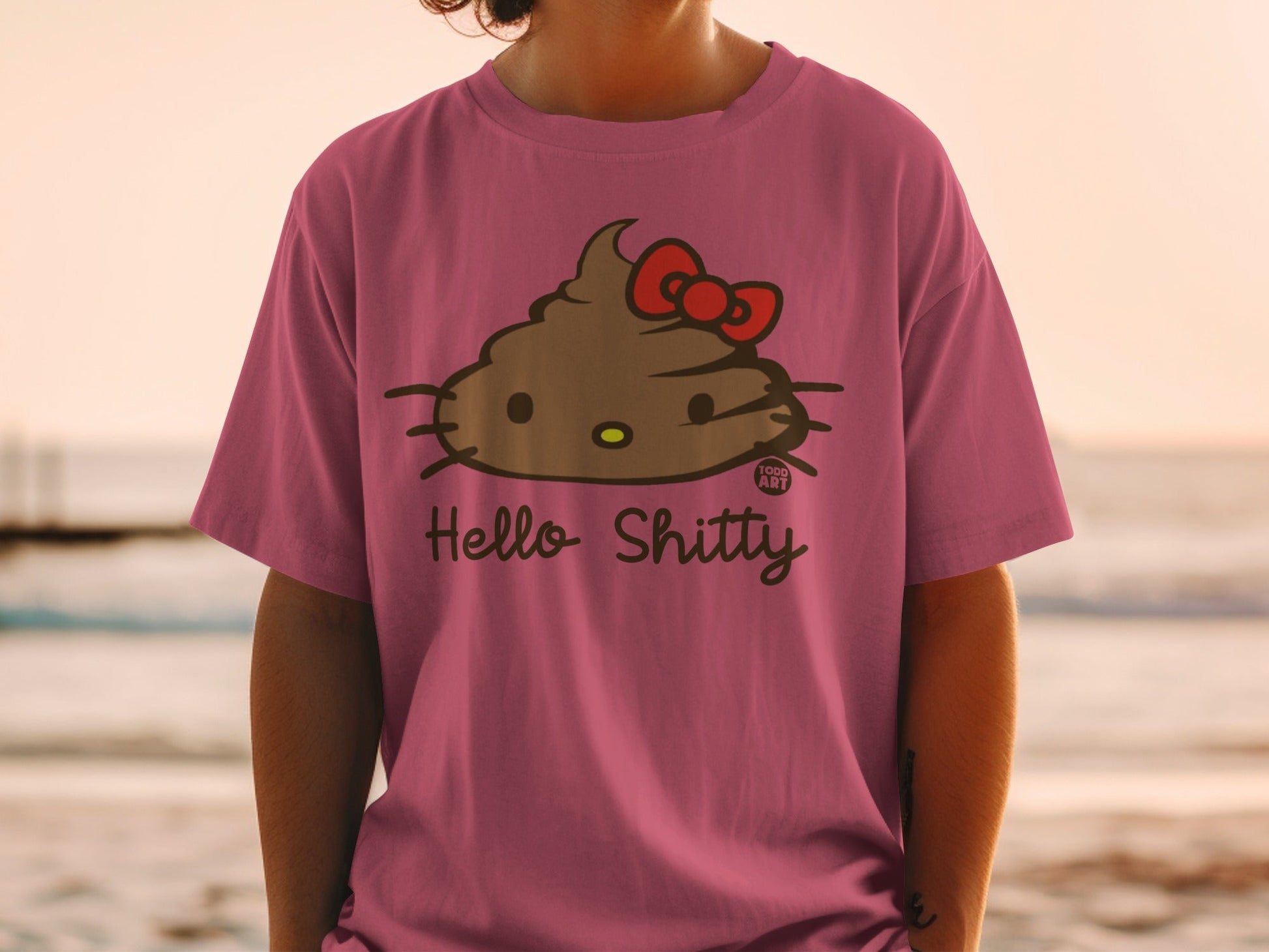 Pink t-shirt with a Hello Kitty-esque poop emoji with a red bow and "Hello Shitty" text.