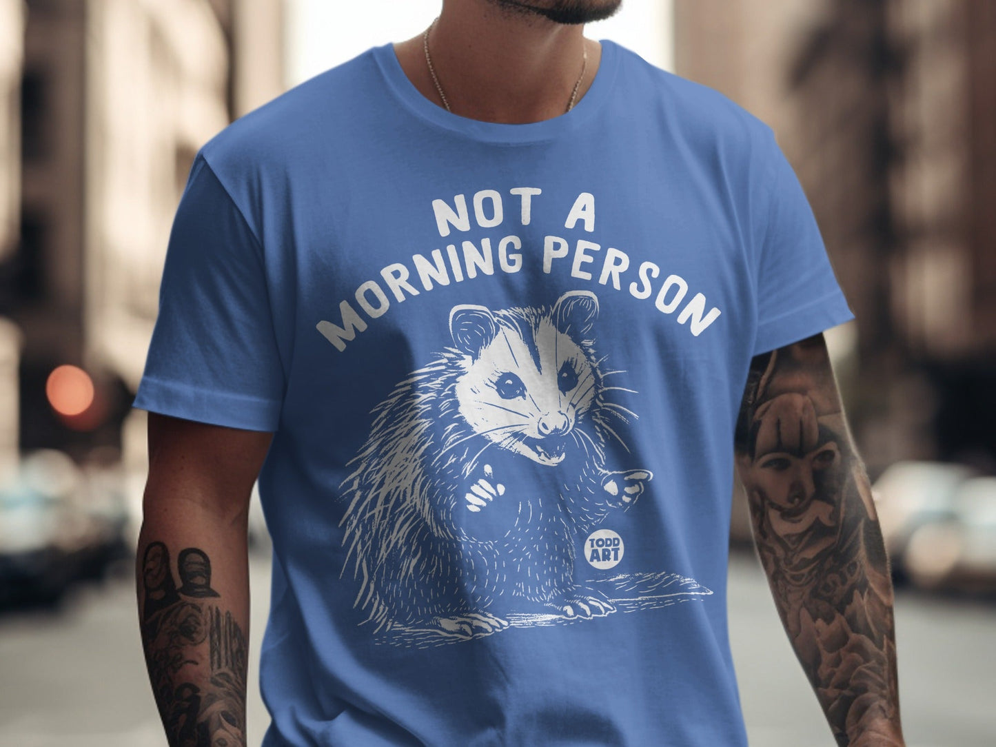 Blue t-shirt with "NOT A MORNING PERSON" and a startled opossum graphic.