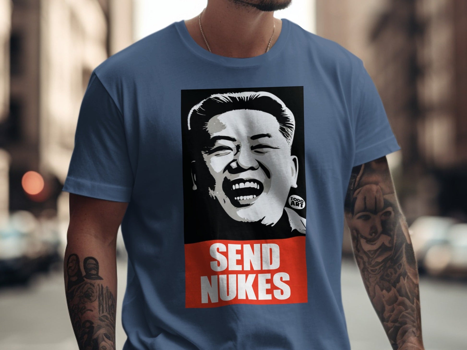 Blue t-shirt with a portrait of Kim Jong Un and "SEND NUKES" text.