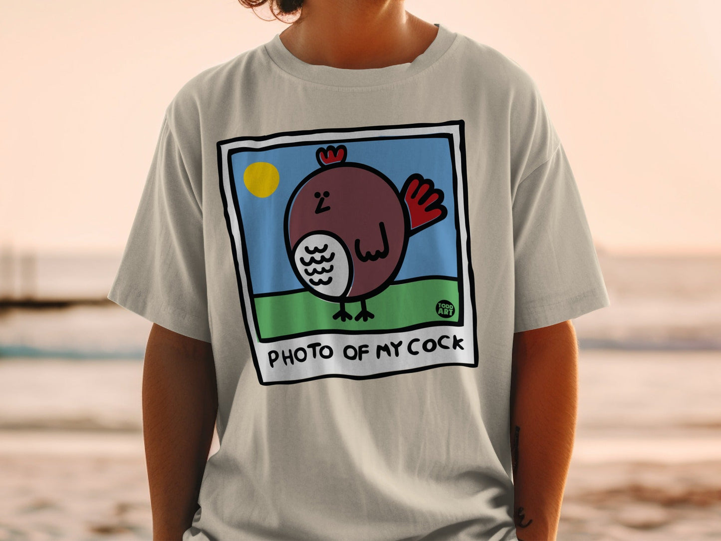 T-shirt with cartoon chicken, sun, and text "PHOTO OF MY COCK".