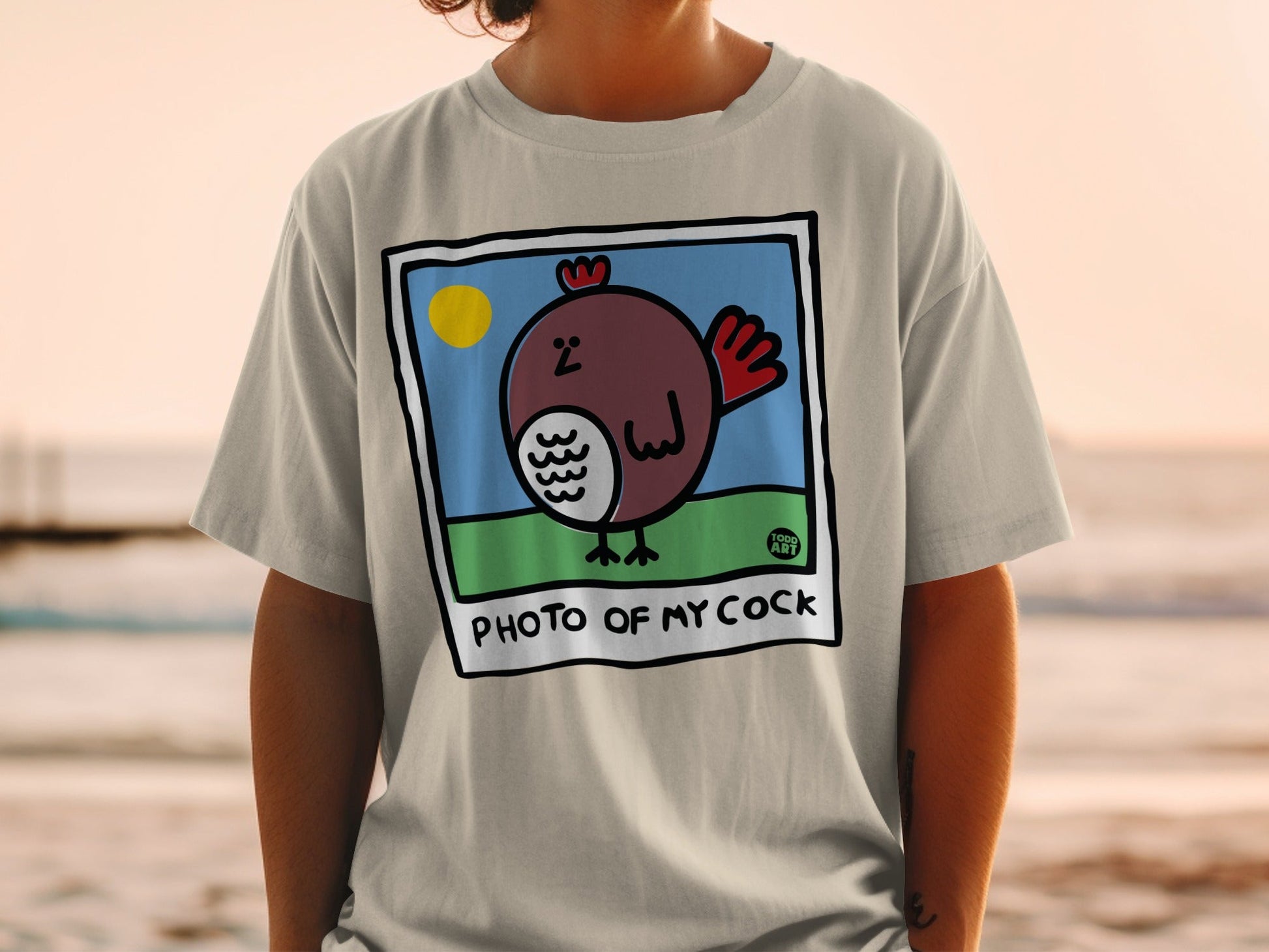 T-shirt with cartoon chicken, sun, and text "PHOTO OF MY COCK".