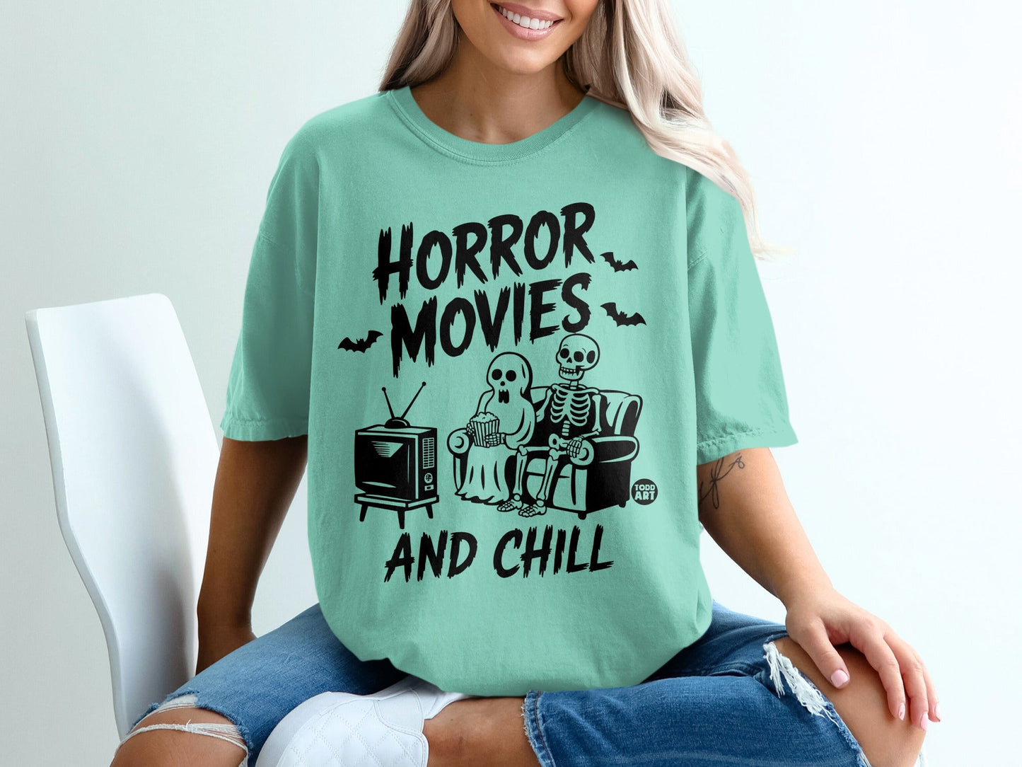 "Horror Movies and Chill" graphic tee with skeleton and ghost watching TV.