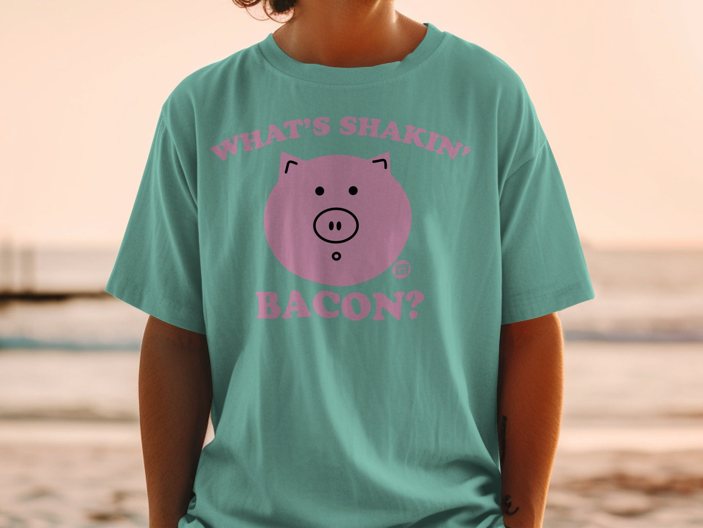 Teal t-shirt with pink pig graphic and "What's shakin' bacon?" text.