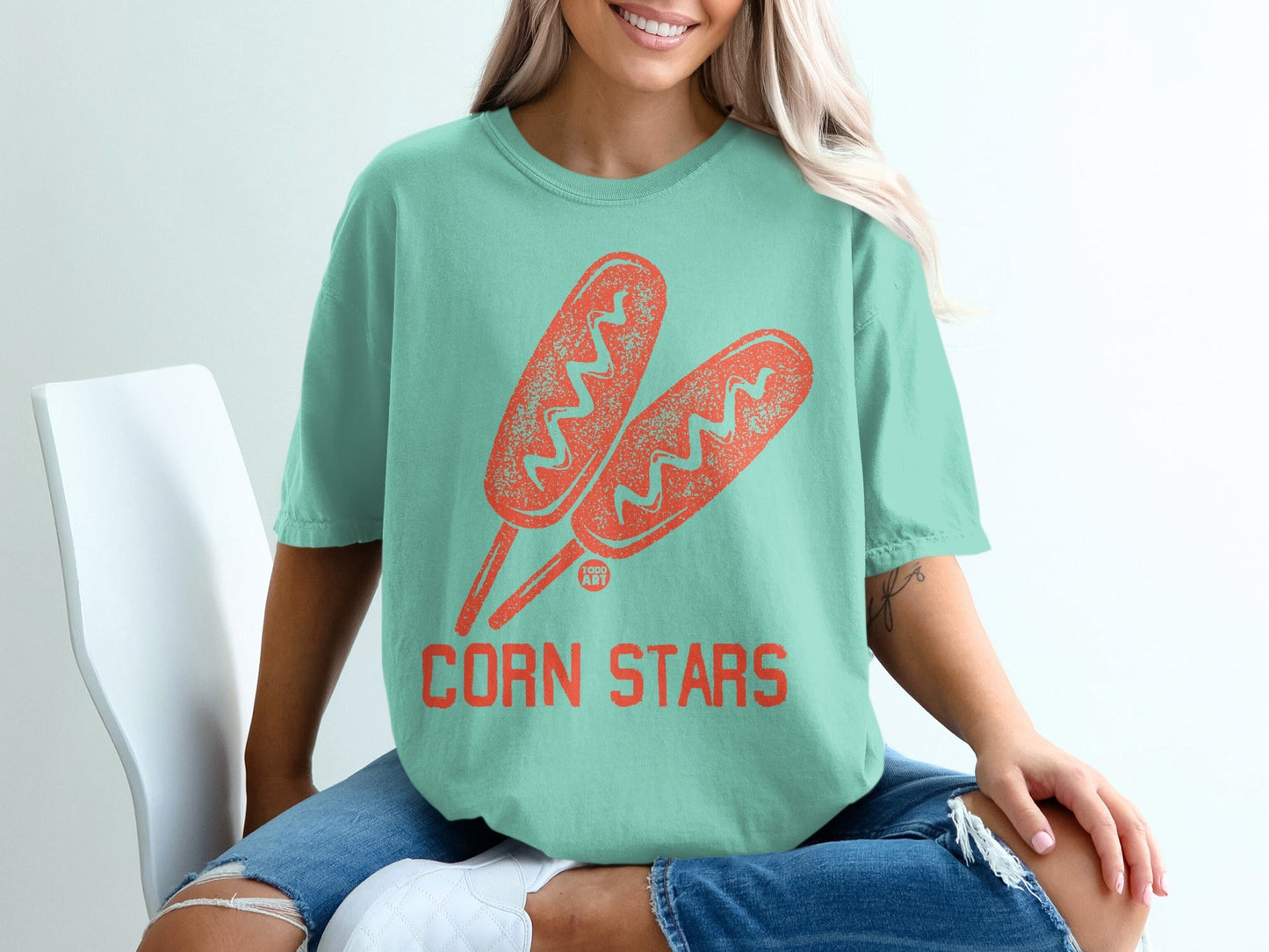 Mint t-shirt with two coral corn dogs and "CORN STARS" text graphic.