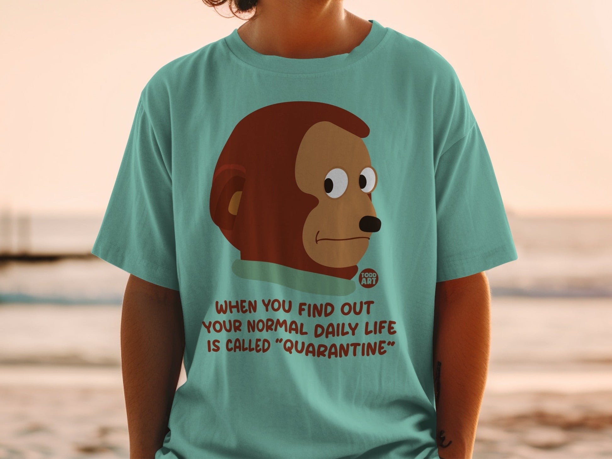 Teal t-shirt with monkey graphic and text "When you find out your normal daily life is called 'Quarantine'".