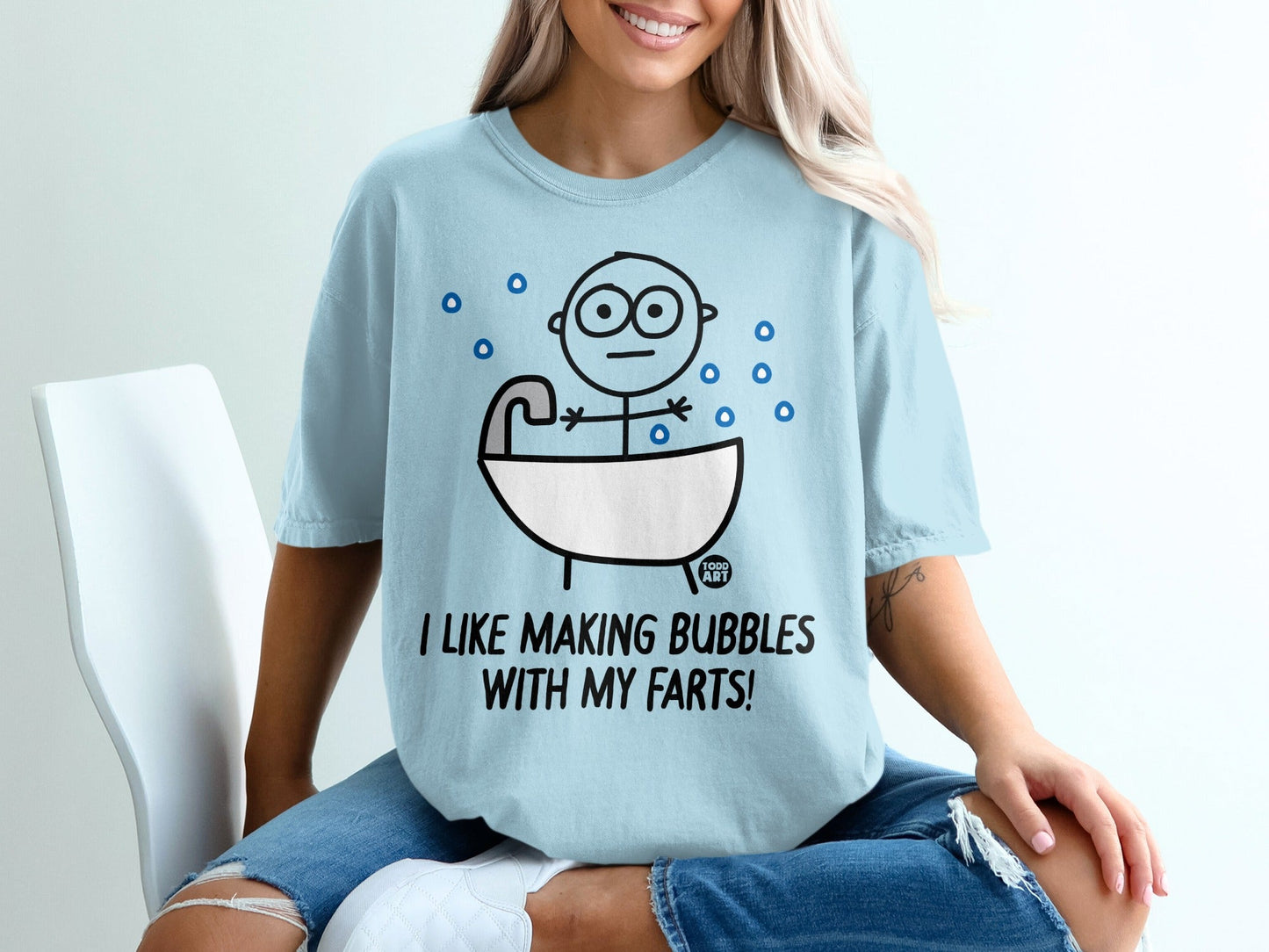 Light blue t-shirt with cartoon person in bathtub and text "I LIKE MAKING BUBBLES WITH MY FARTS!".