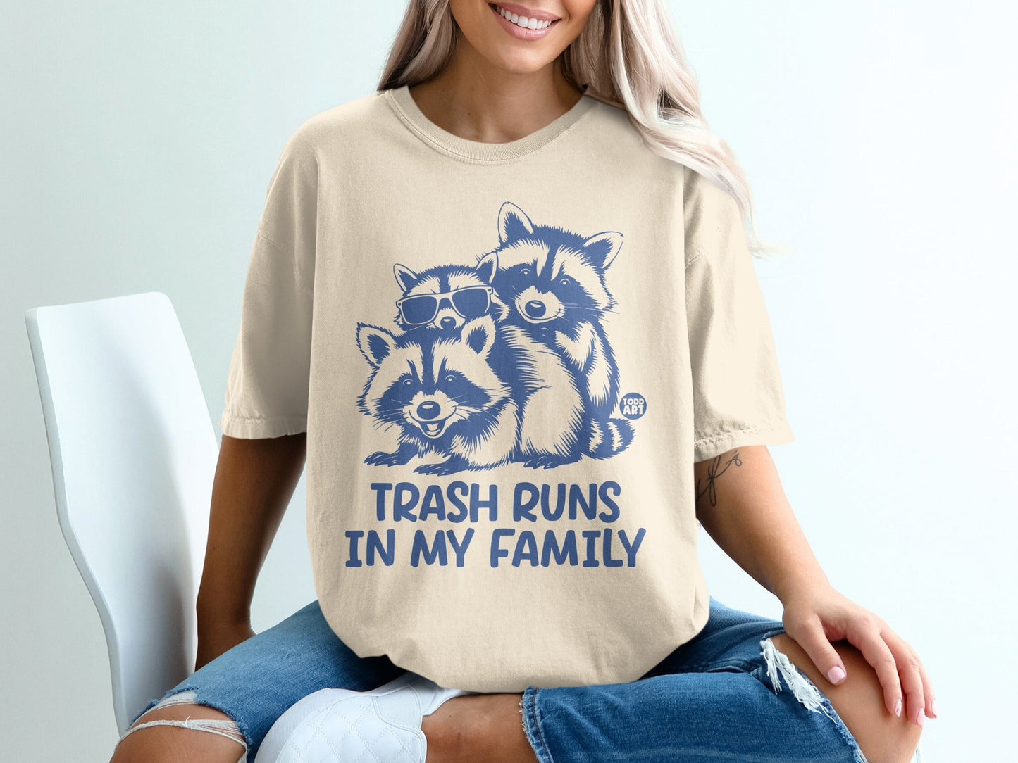 T-shirt with two raccoons, one wearing sunglasses, saying "Trash Runs In My Family."