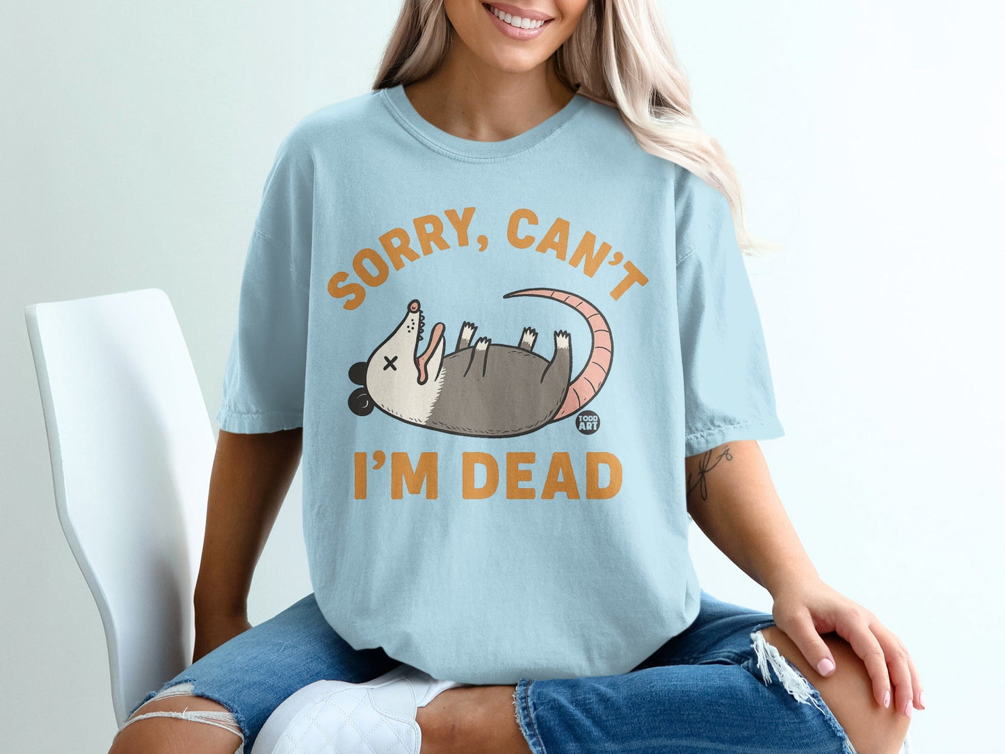 Light blue t-shirt with possum graphic and "SORRY, CAN'T I'M DEAD" text.