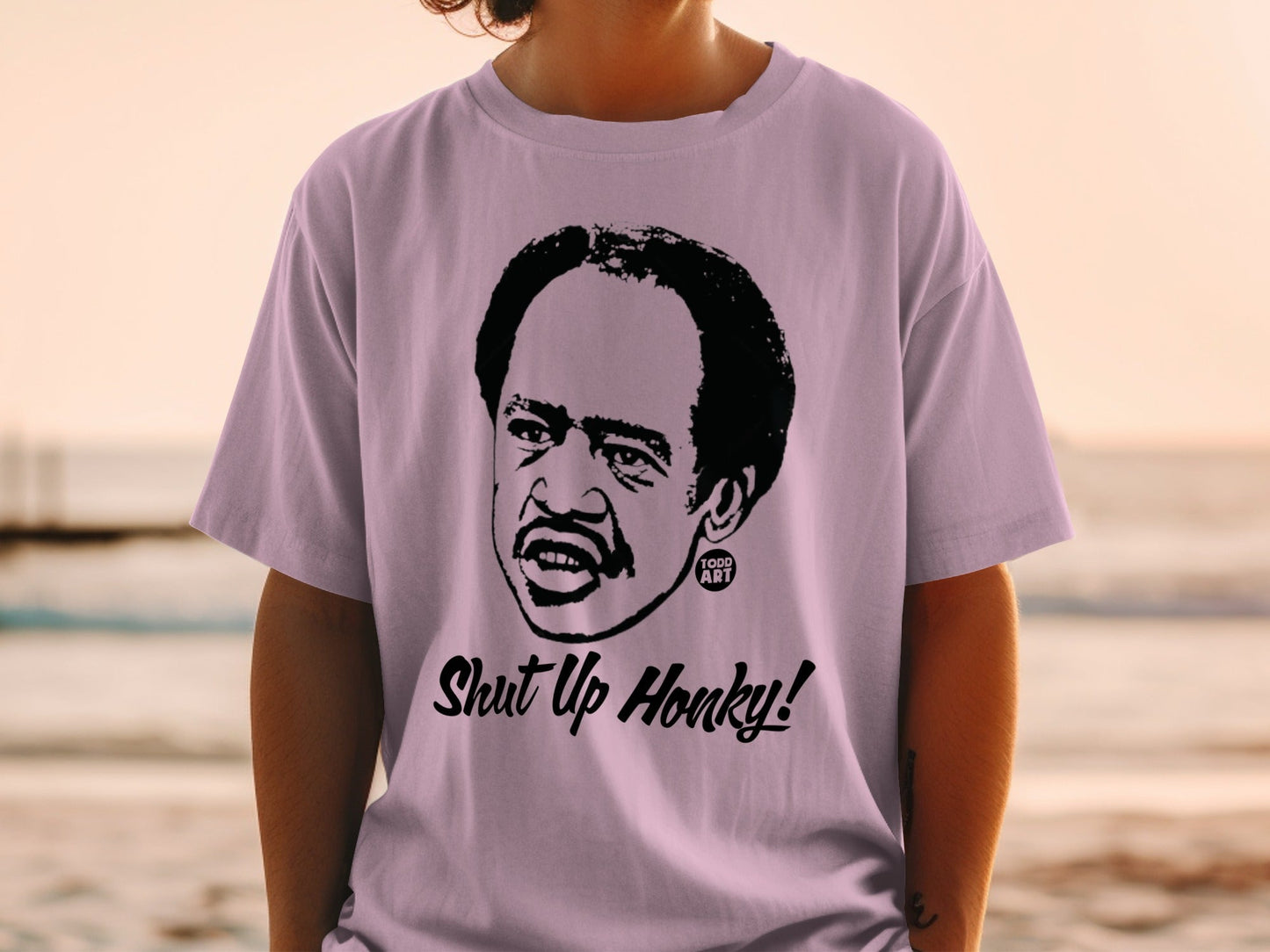 Lilac t-shirt featuring a black graphic of Richard Pryor saying "Shut Up Honky!".