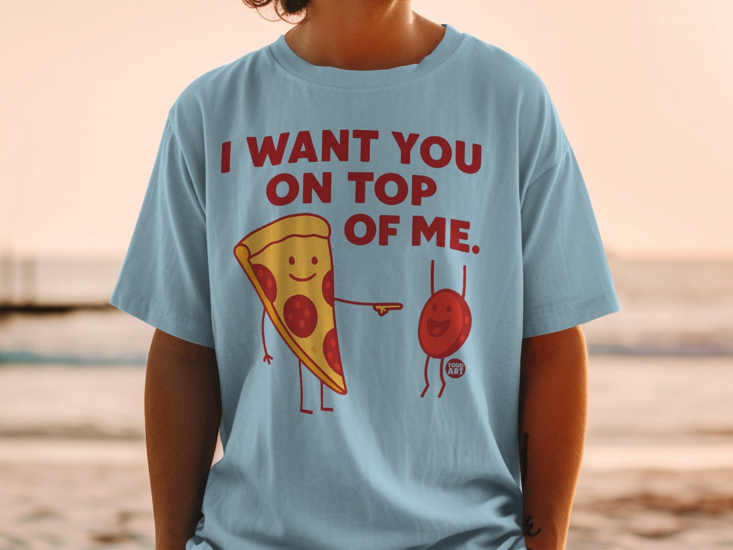 Light blue t-shirt with cartoon pizza slice and a small red blob on it.