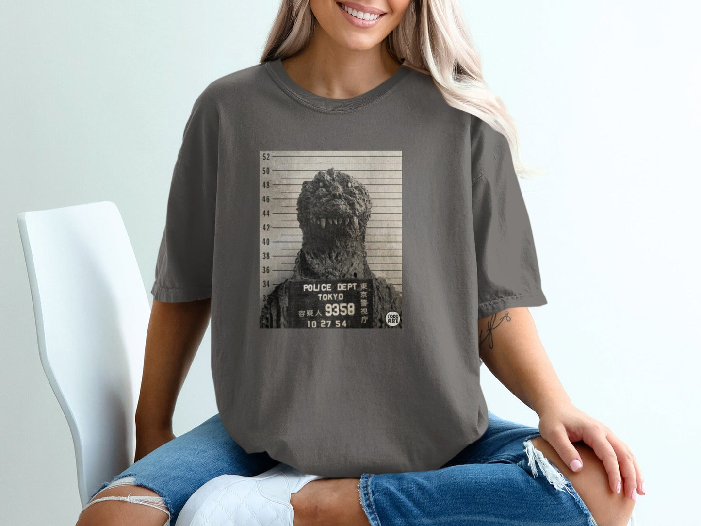 Godzilla mugshot graphic on dark grey t-shirt.