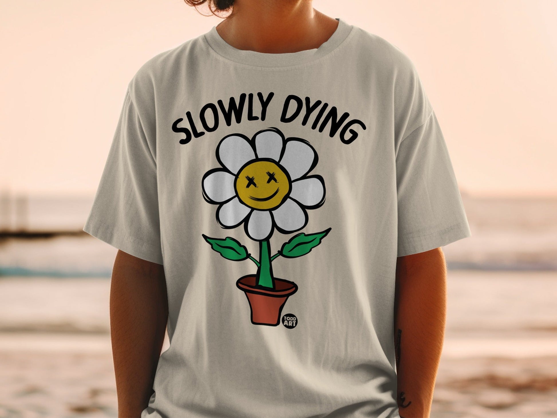 T-shirt with cartoon flower, "SLOWLY DYING" text, and flower pot.