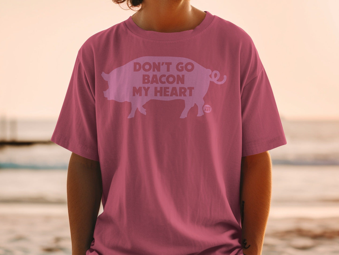 Pink t-shirt with a pig silhouette and "Don't Go Bacon My Heart" text.