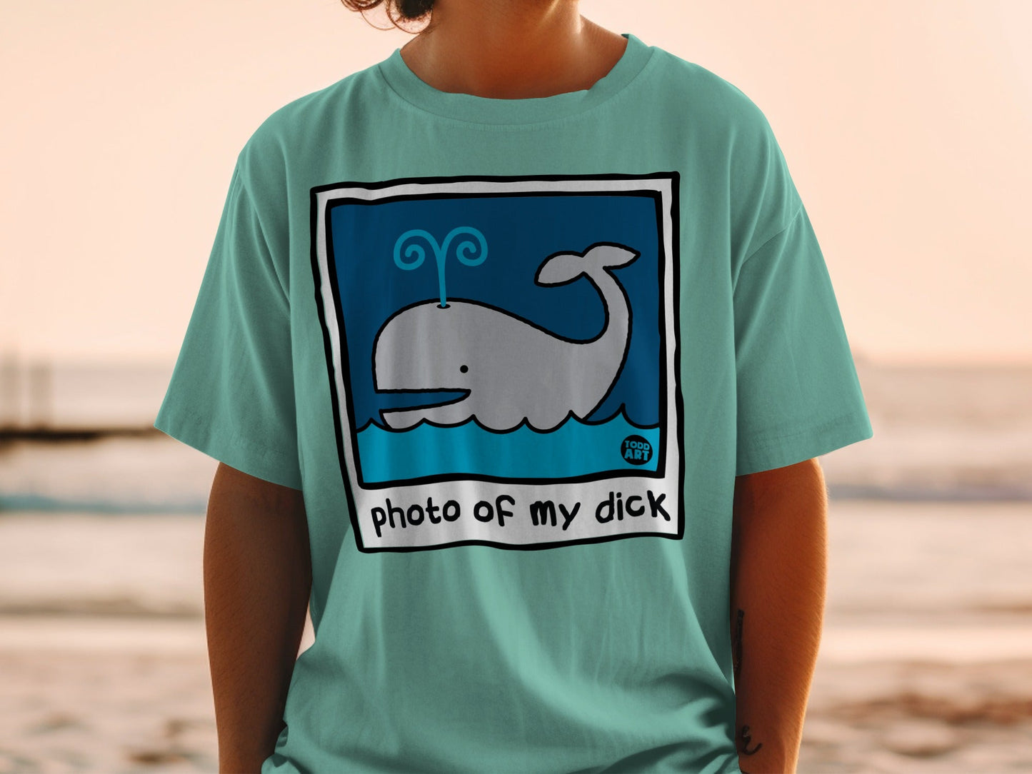 Teal t-shirt with a cartoon whale illustration and text "photo of my dick".