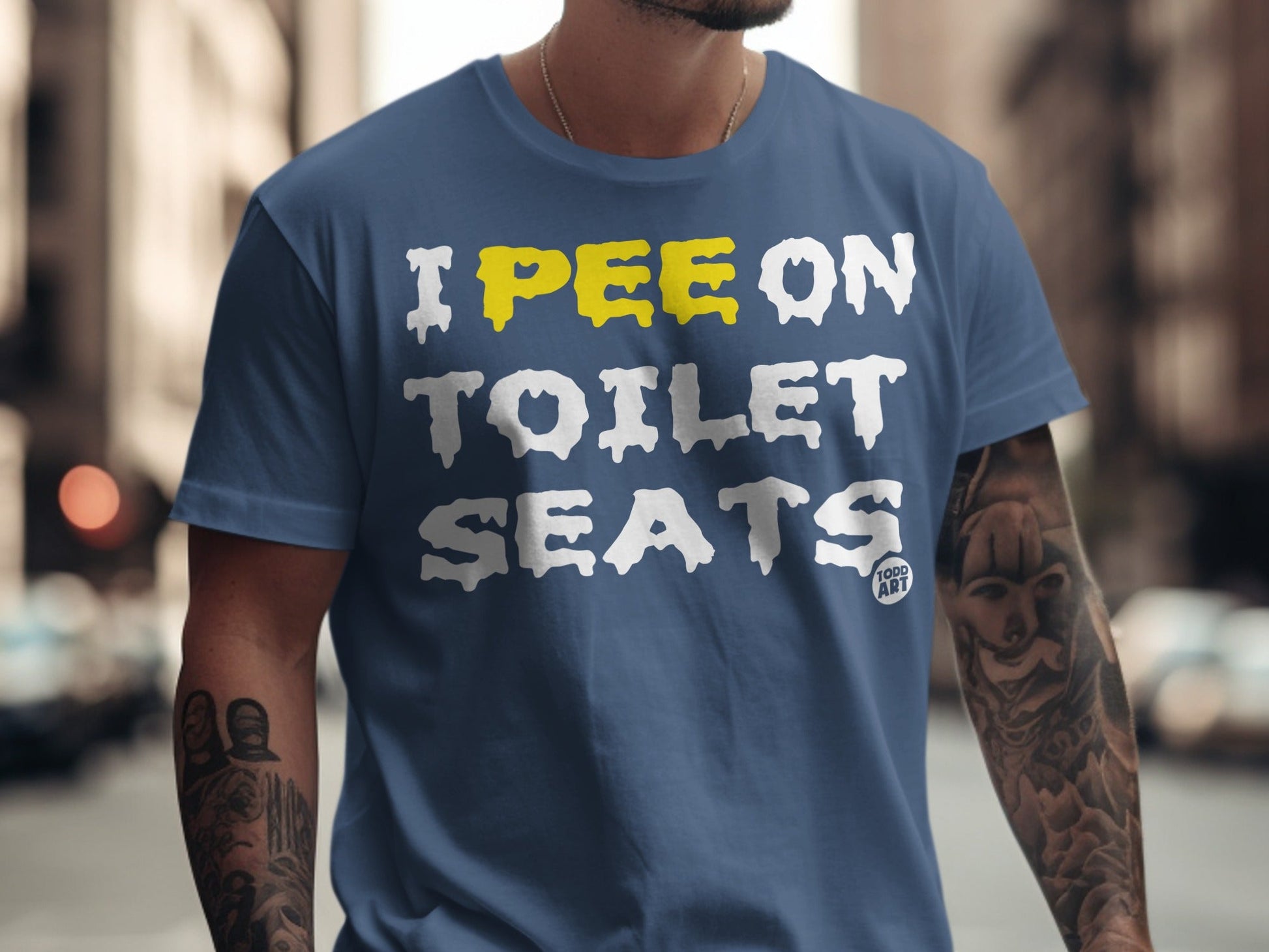 Blue t-shirt with white text "I PEE ON TOILET SEATS" and yellow "PEE".