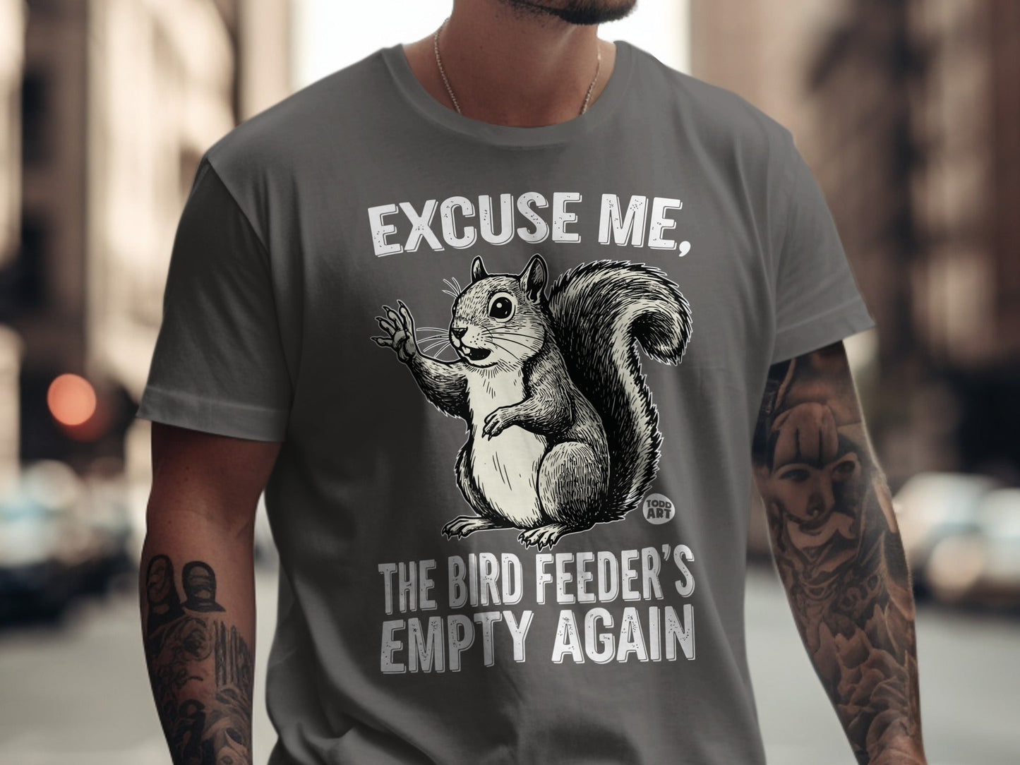 Gray t-shirt with a squirrel saying "Excuse me, the bird feeder's empty again".