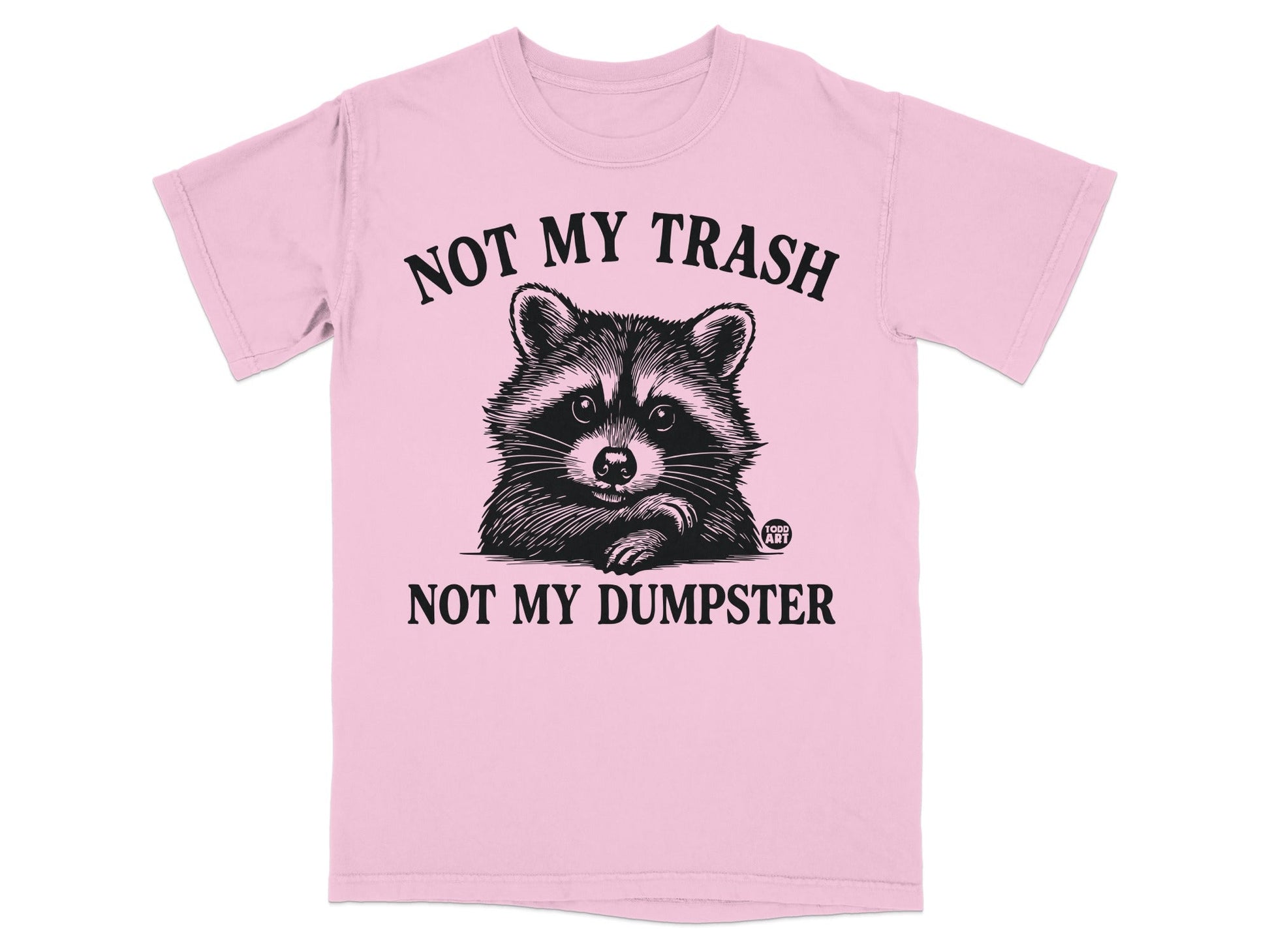 Pink t-shirt with raccoon illustration and text "NOT MY TRASH NOT MY DUMPSTER".
