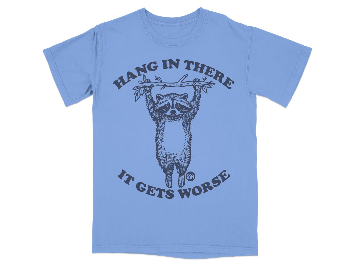Light blue t-shirt with raccoon hanging from branch, "Hang in there it gets worse" text.