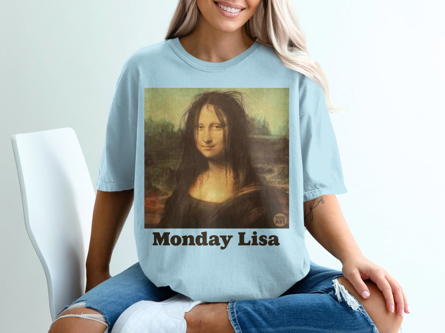 Light blue t-shirt with "Monday Lisa" and Mona Lisa painting.