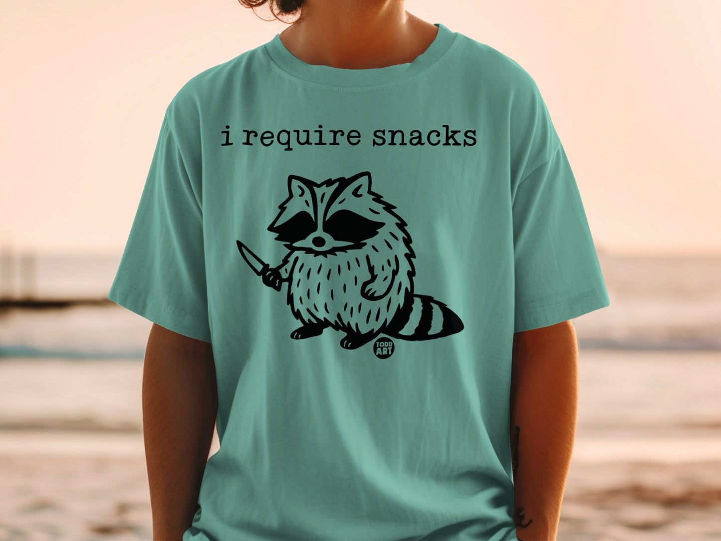 Raccoon holding a knife with "I require snacks" and "100d ART" text.