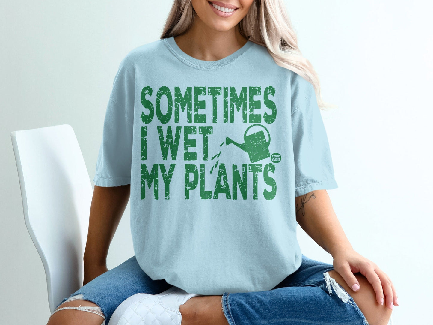 Light blue t-shirt with "Sometimes I Wet My Plants" and watering can graphic.