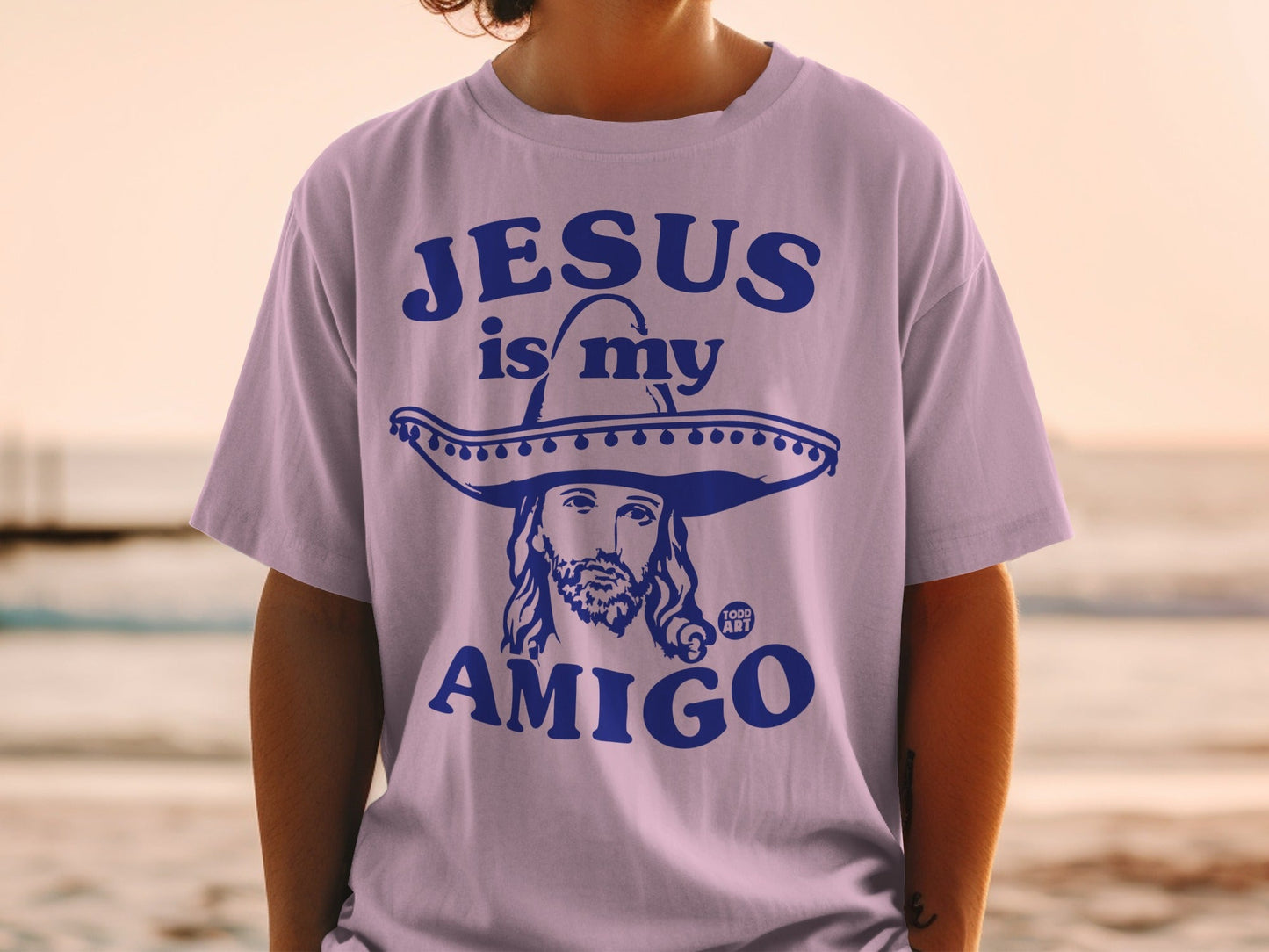 Purple t-shirt with "Jesus is my amigo" text and a sombrero-wearing Jesus graphic.
