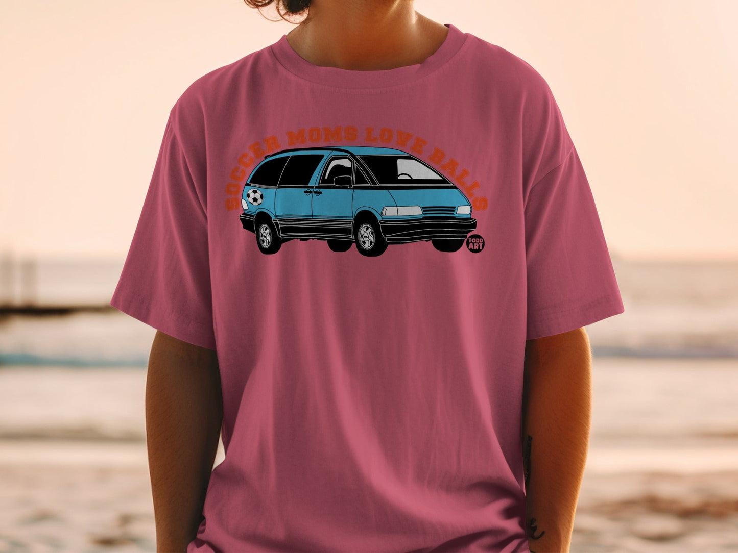 Pink t-shirt with blue minivan graphic and text "Soccer Moms Love Balls".