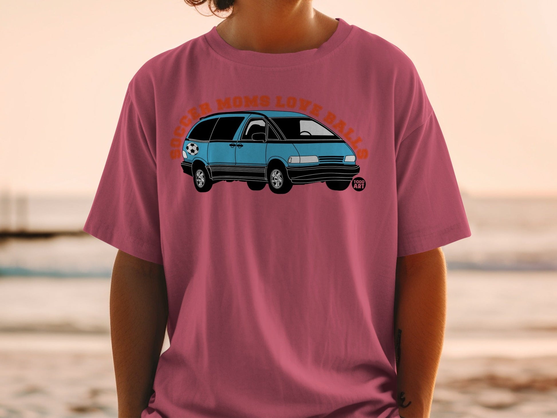 Pink t-shirt with blue minivan graphic and text "Soccer Moms Love Balls".