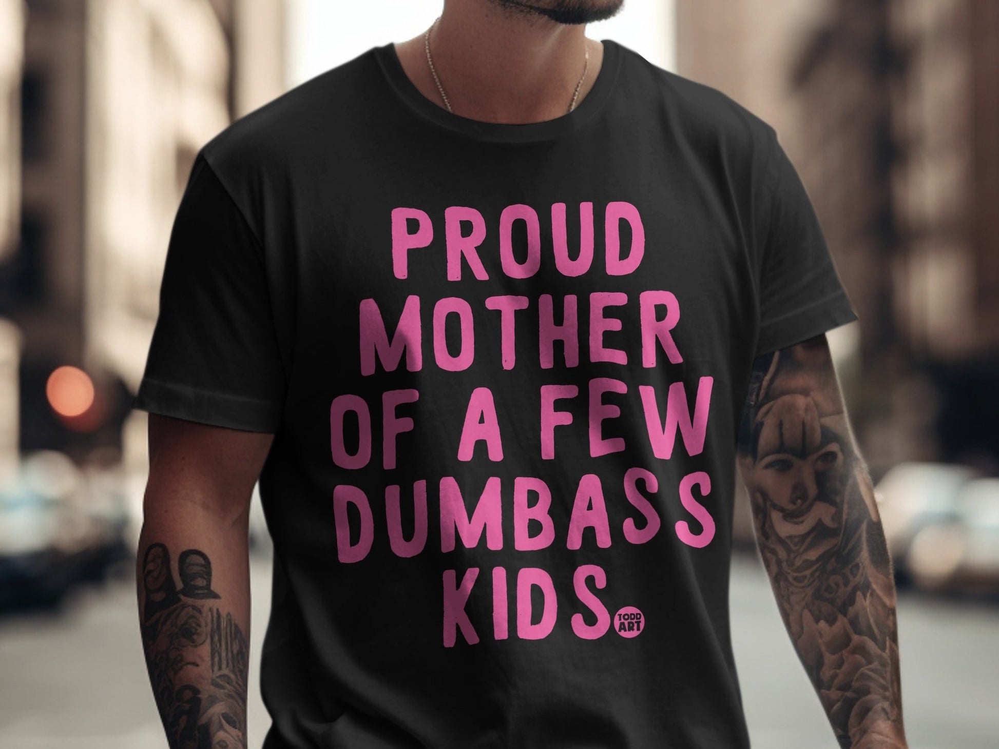 Black t-shirt with "Proud Mother of a Few Dumbass Kids" in pink text.