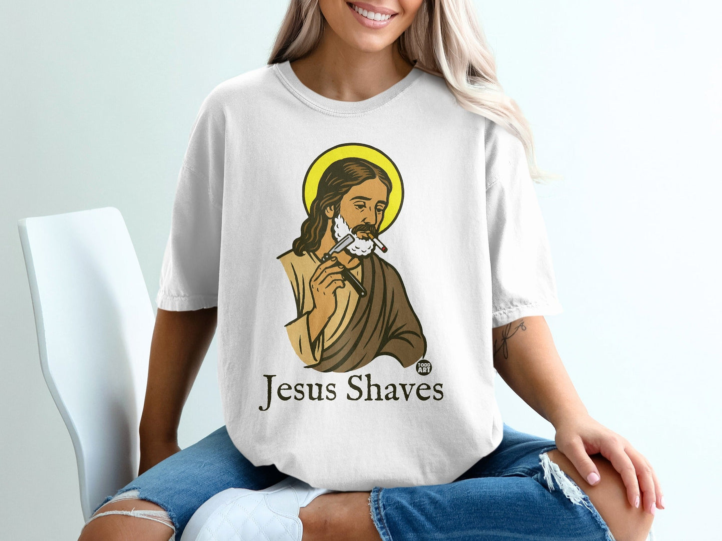 T-shirt with illustration of Jesus shaving, text "Jesus Shaves".