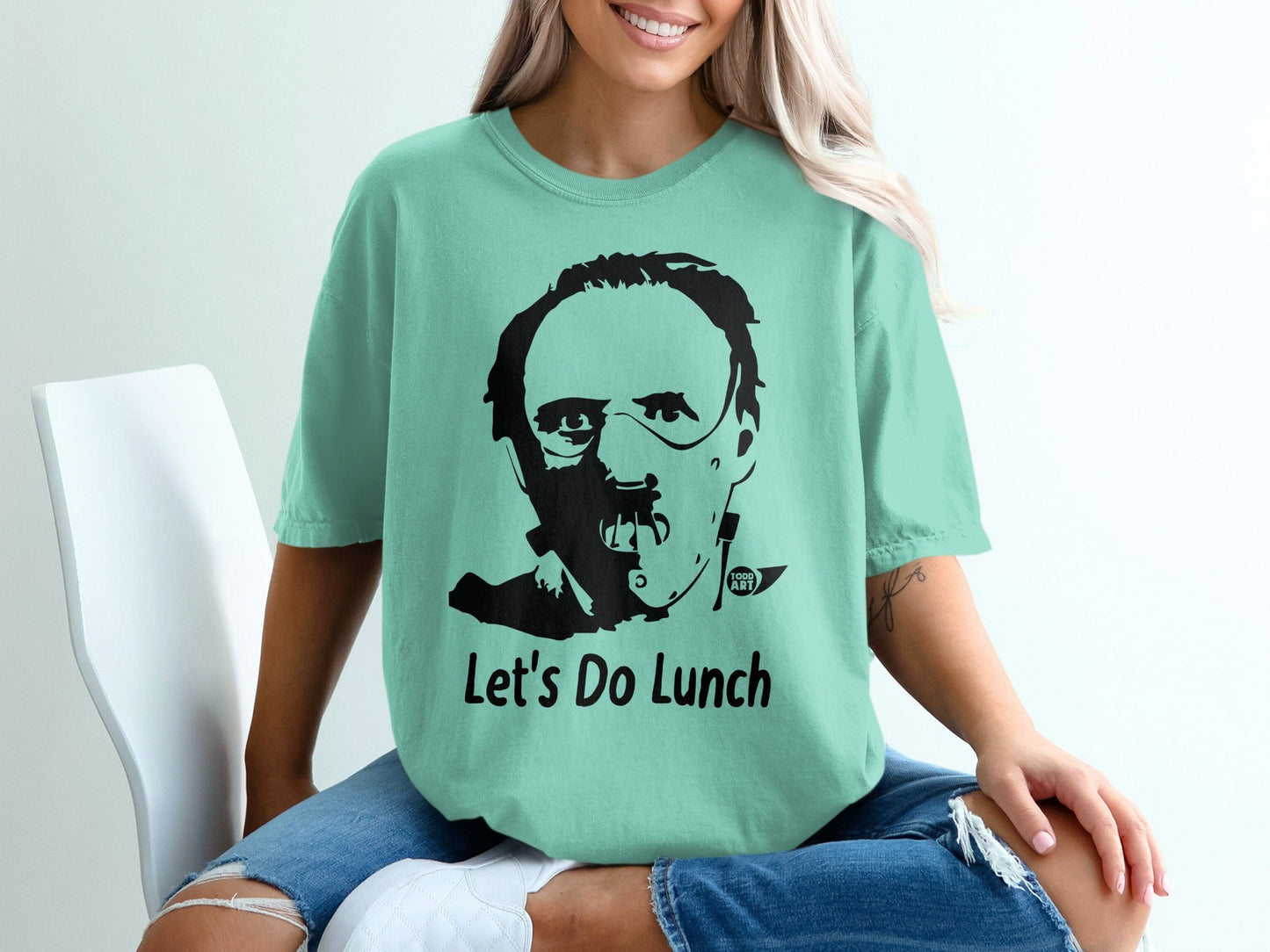 Mint t-shirt with black graphic of Hannibal Lecter and text "Let's Do Lunch".