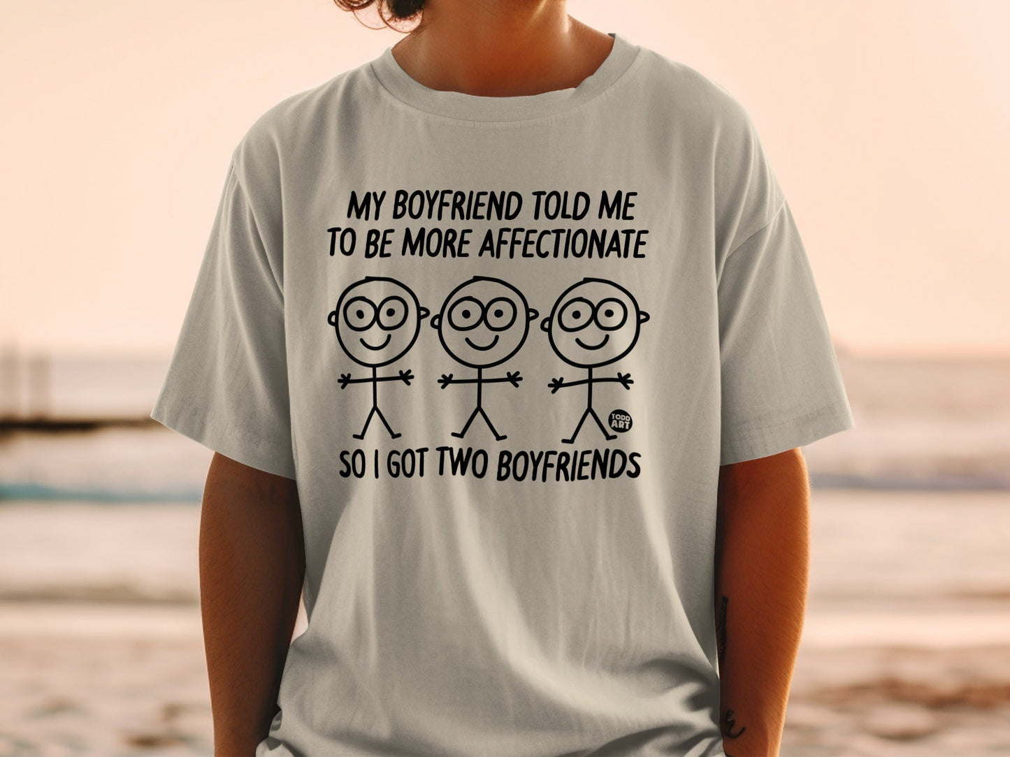 T-shirt with stick figures and text: "MY BOYFRIEND TOLD ME TO BE MORE AFFECTIONATE SO I GOT TWO BOYFRIENDS"
