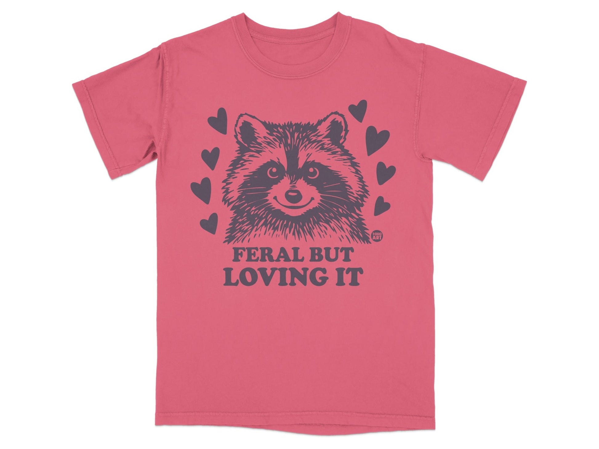 T-shirt with raccoon graphic and text "FERAL BUT LOVING IT" surrounded by hearts.