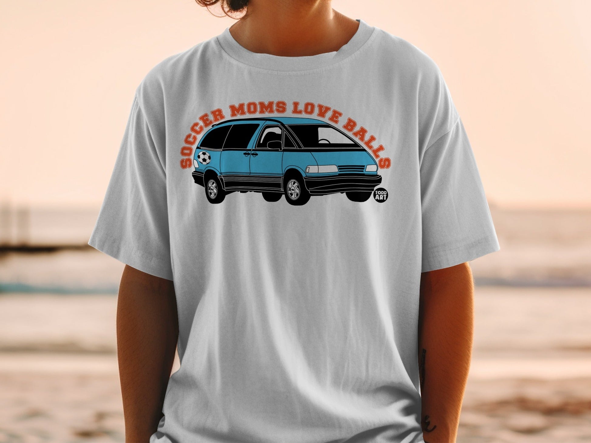 Light blue minivan with a soccer ball, text "Soccer Moms Love Balls".