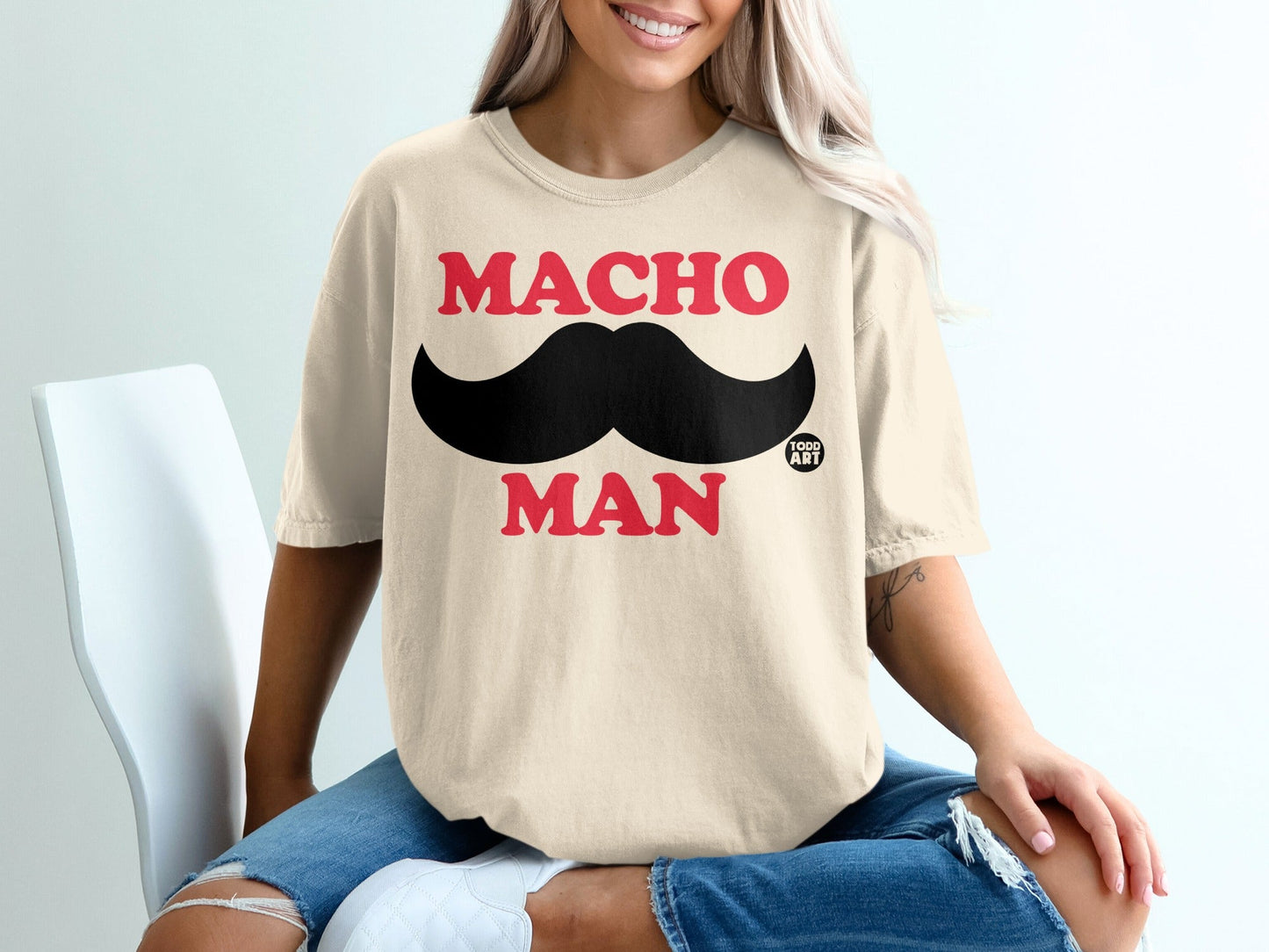 Cream t-shirt with "MACHO MAN" text and black mustache graphic.