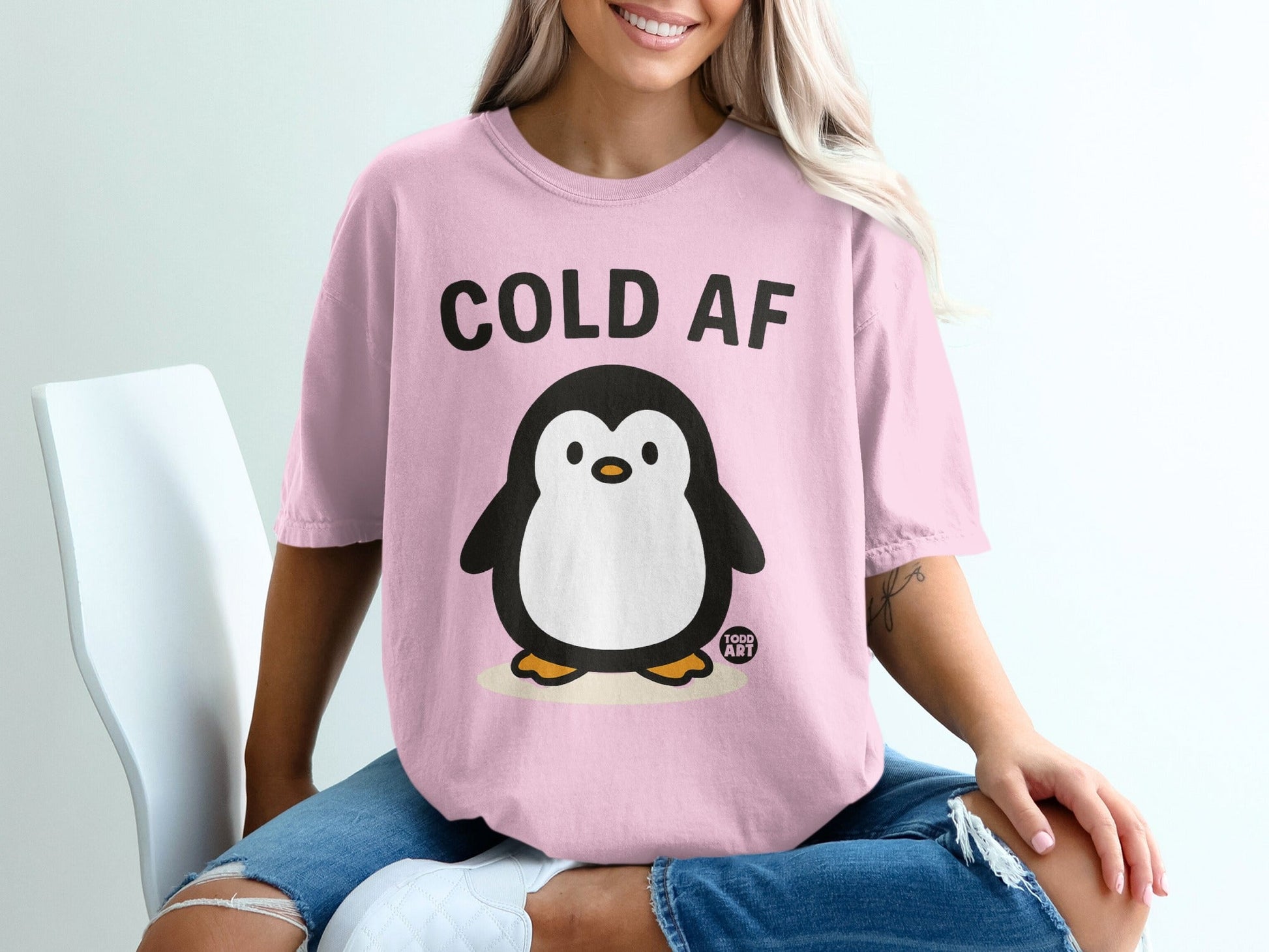 Pink t-shirt with a cartoon penguin and "COLD AF" text.