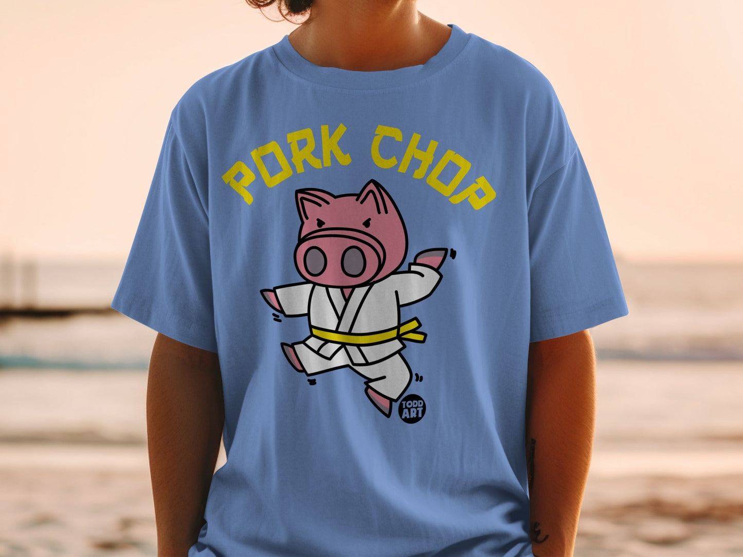 Cartoon pig in a karate gi doing a jumping kick, text PORK CHOP.
