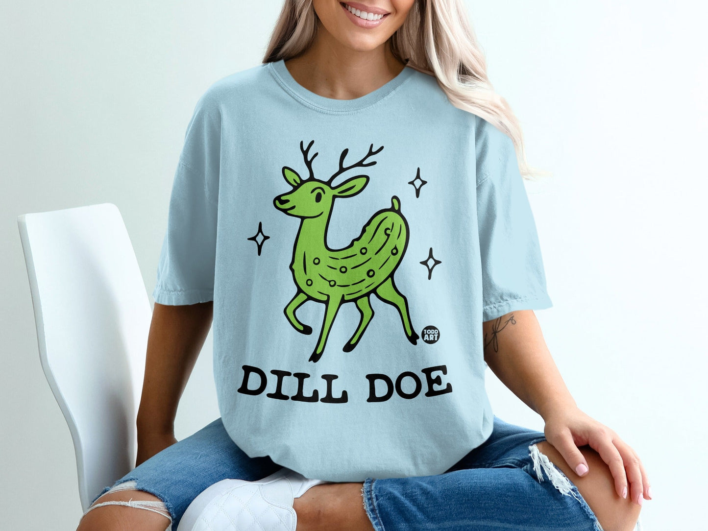 Light blue t-shirt with cartoon dill pickle deer graphic and "DILL DOE" text.