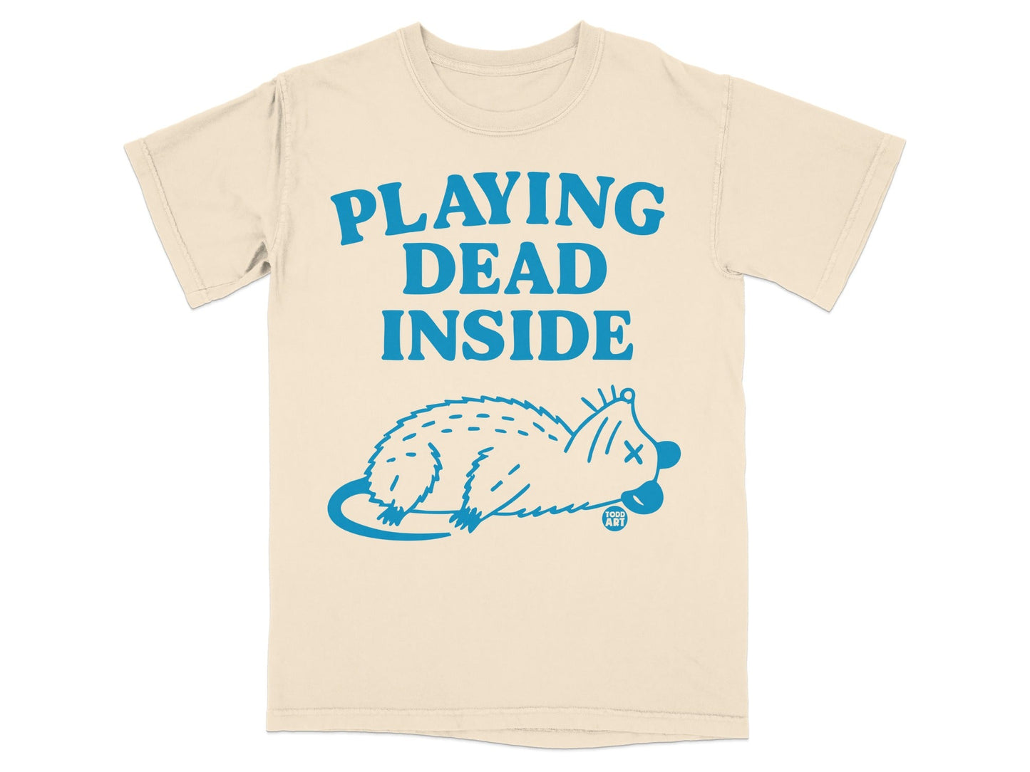 Cream t-shirt with blue text "PLAYING DEAD INSIDE" and a blue cartoon opossum.
