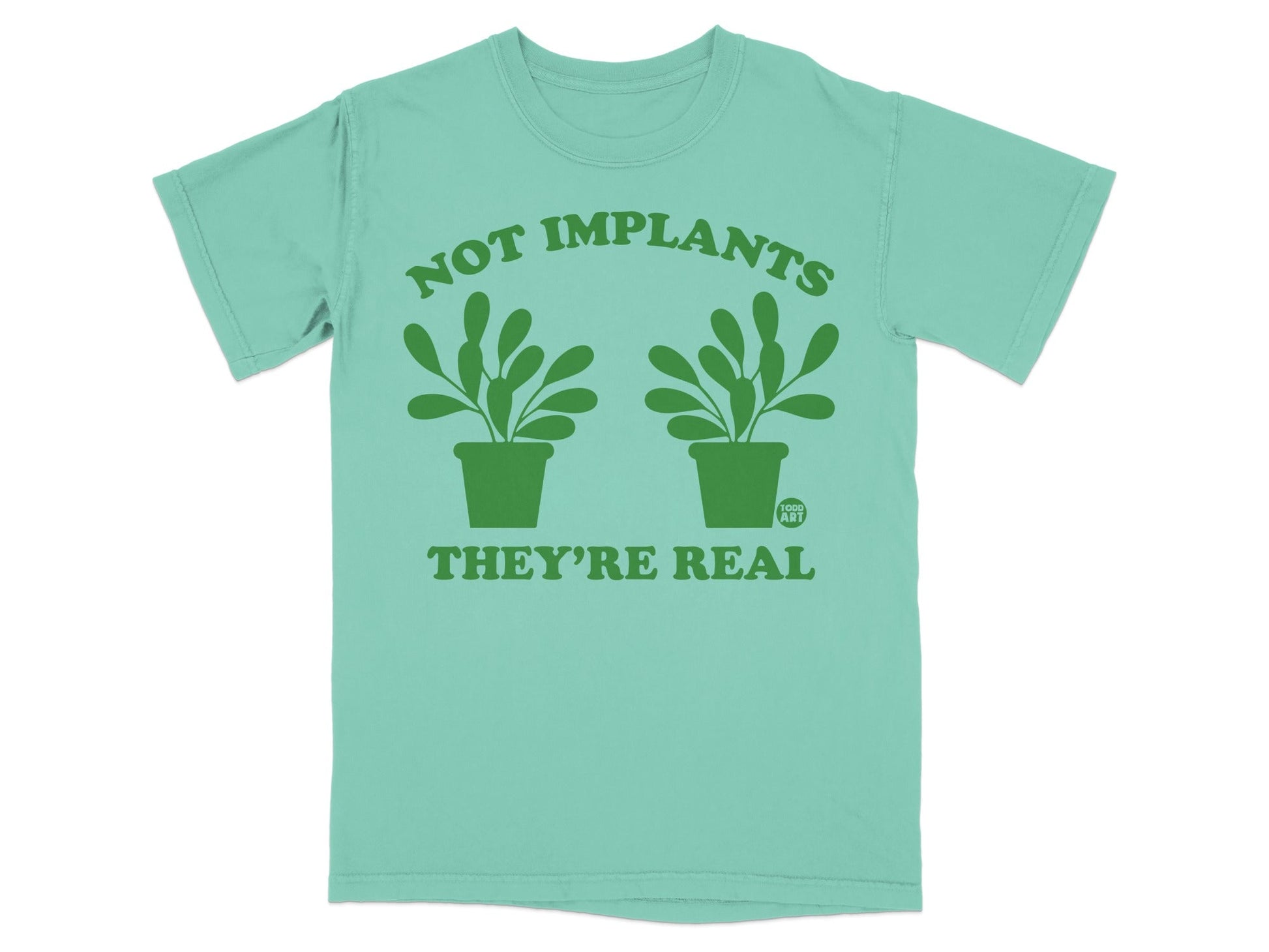 Mint t-shirt with green text "NOT IMPLANTS THEY'RE REAL" and two potted plants.