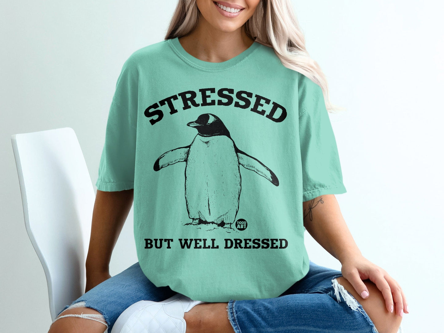Mint t-shirt with "STRESSED BUT WELL DRESSED" text and penguin graphic.