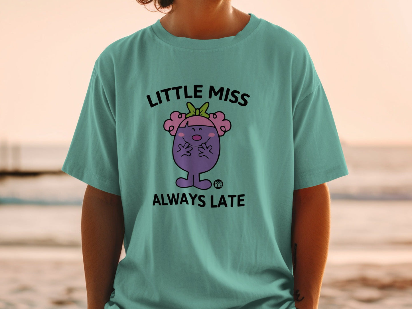 Teal t-shirt with "Little Miss Always Late" cartoon character graphic.