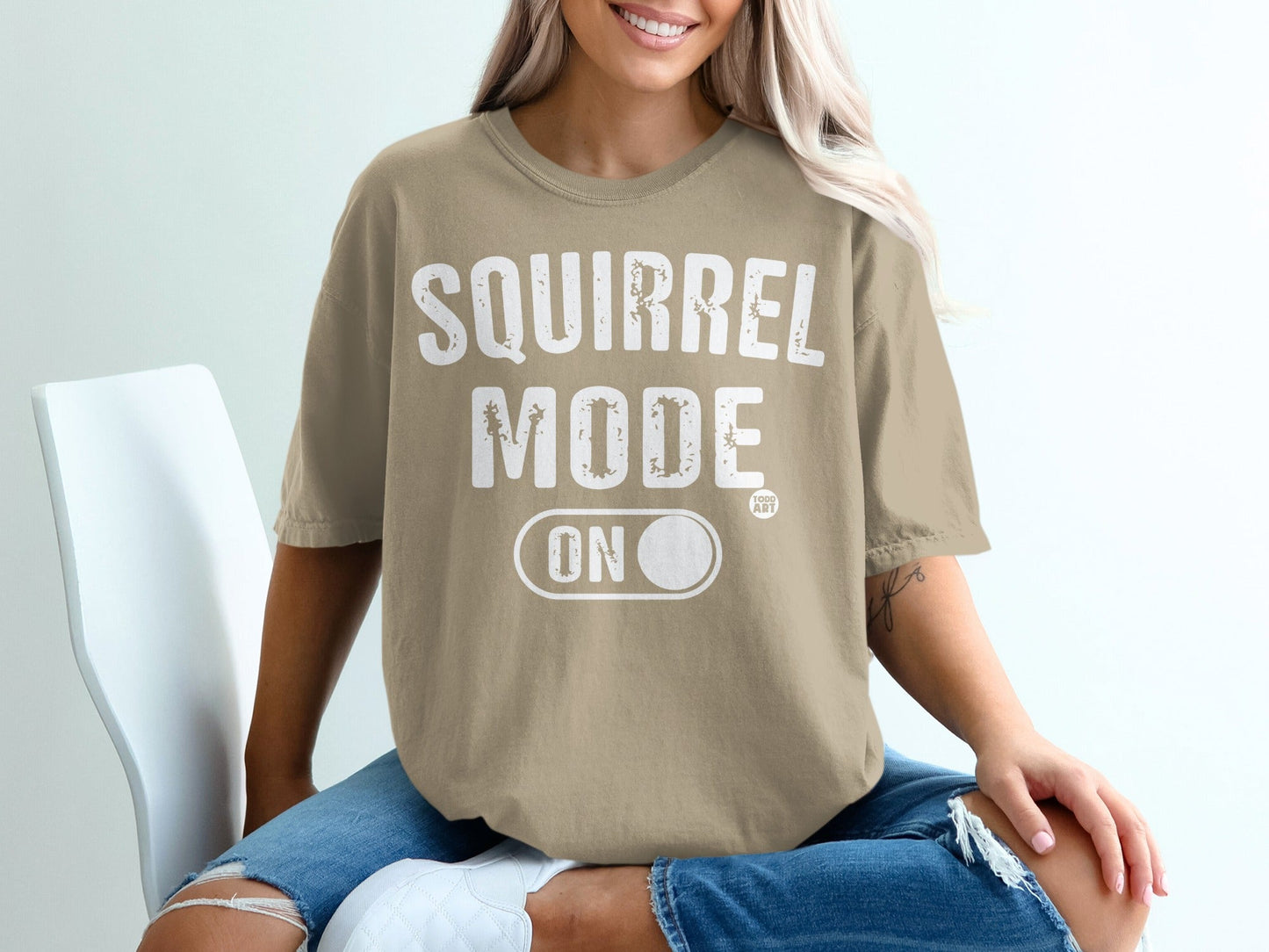 T-shirt with "SQUIRREL MODE ON" text, worn by a woman.