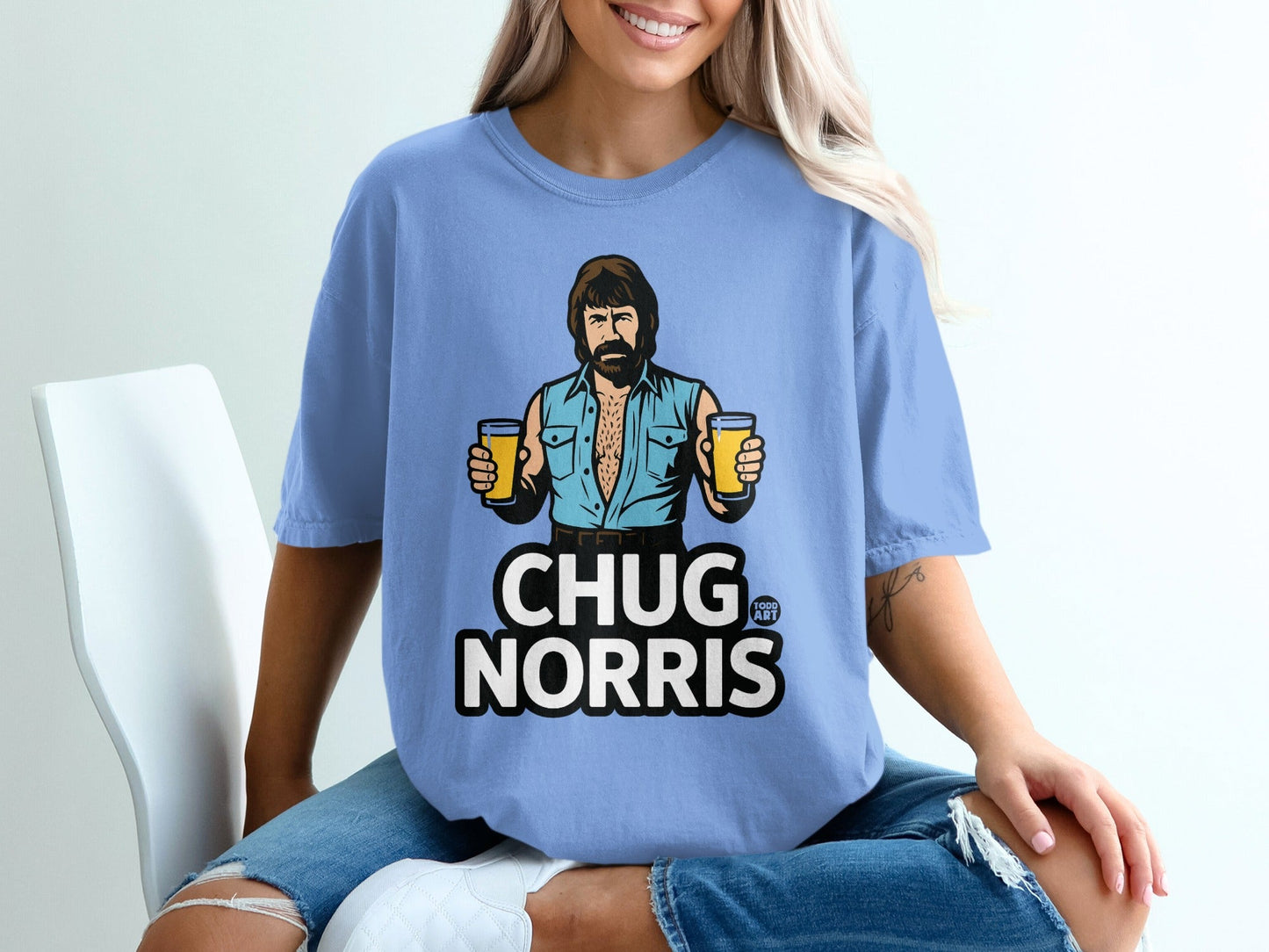 Light blue t-shirt with Chuck Norris holding two beers and text "CHUG NORRIS".