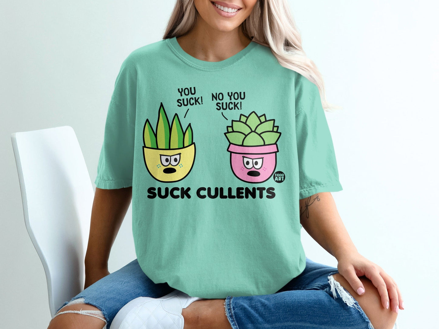 Two cartoon succulents on a shirt saying "You suck! No you suck! Suck cullents."