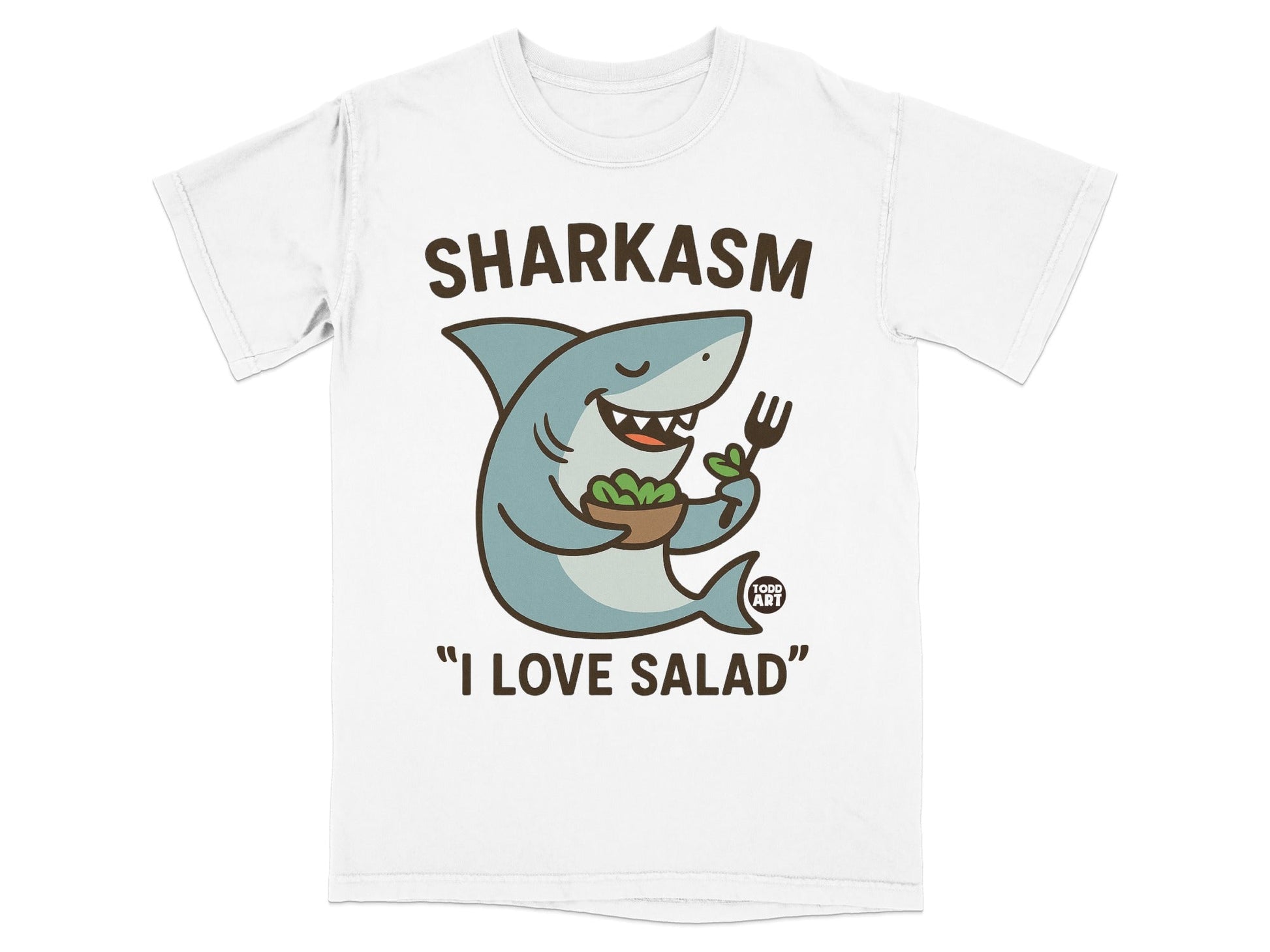White t-shirt with cartoon shark holding salad and fork, text "SHARKASM" and "I LOVE SALAD".