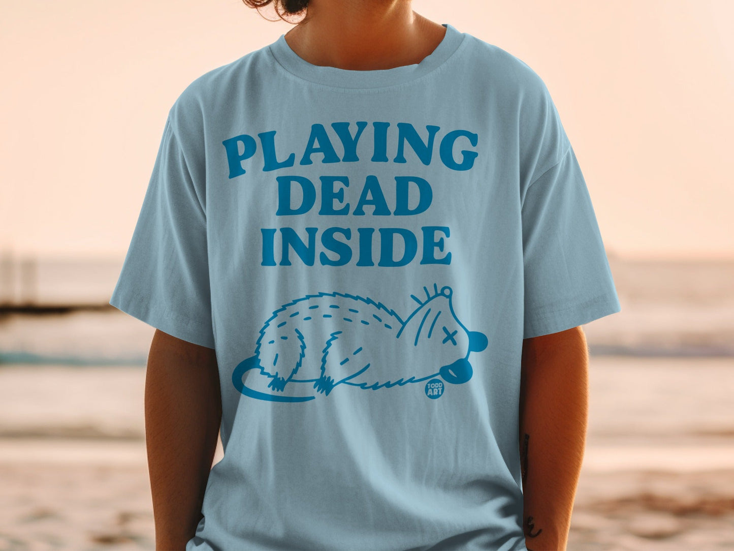 Light blue t-shirt with "PLAYING DEAD INSIDE" and a possum graphic.